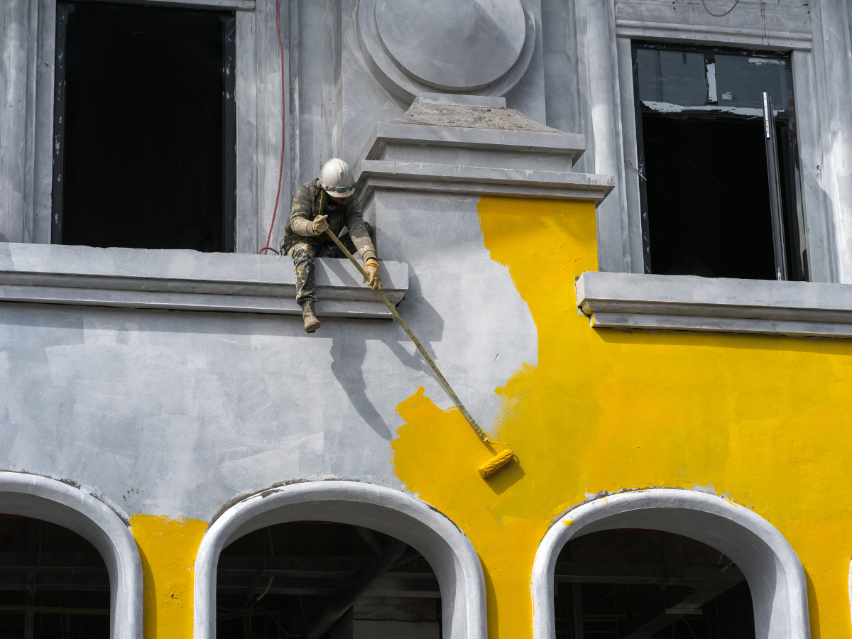 Bank building with cars parked out front on a sunny day. Green lawn and blue sky.