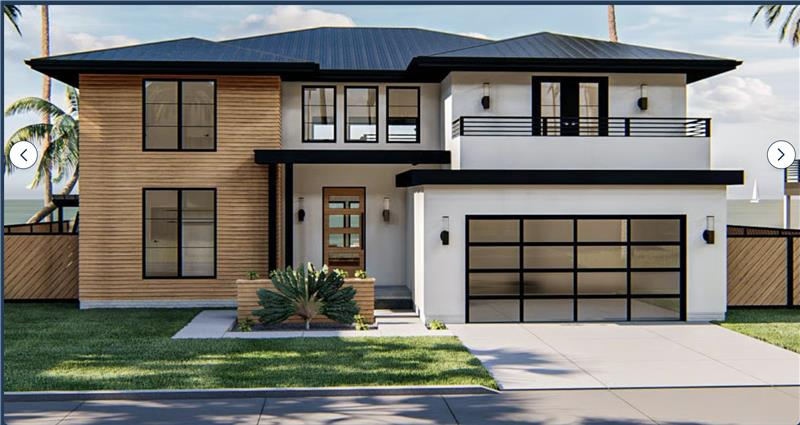 A large house with a garage and a driveway on a rainy day.