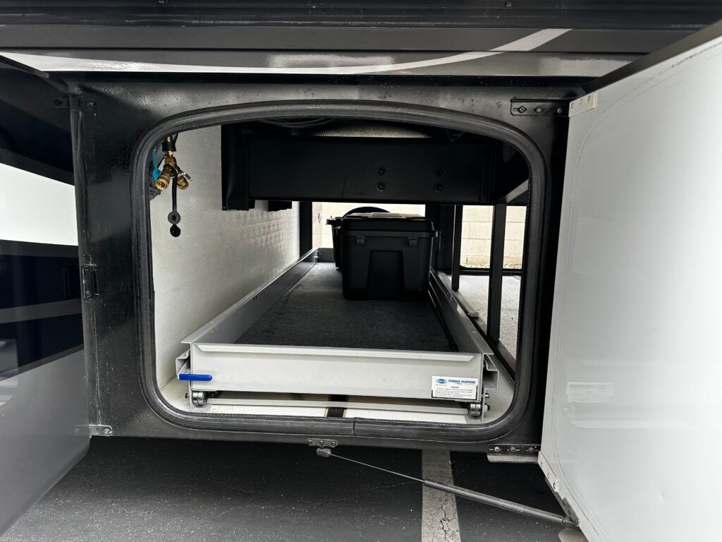 The inside of a rv with the door open and a drawer in the back.