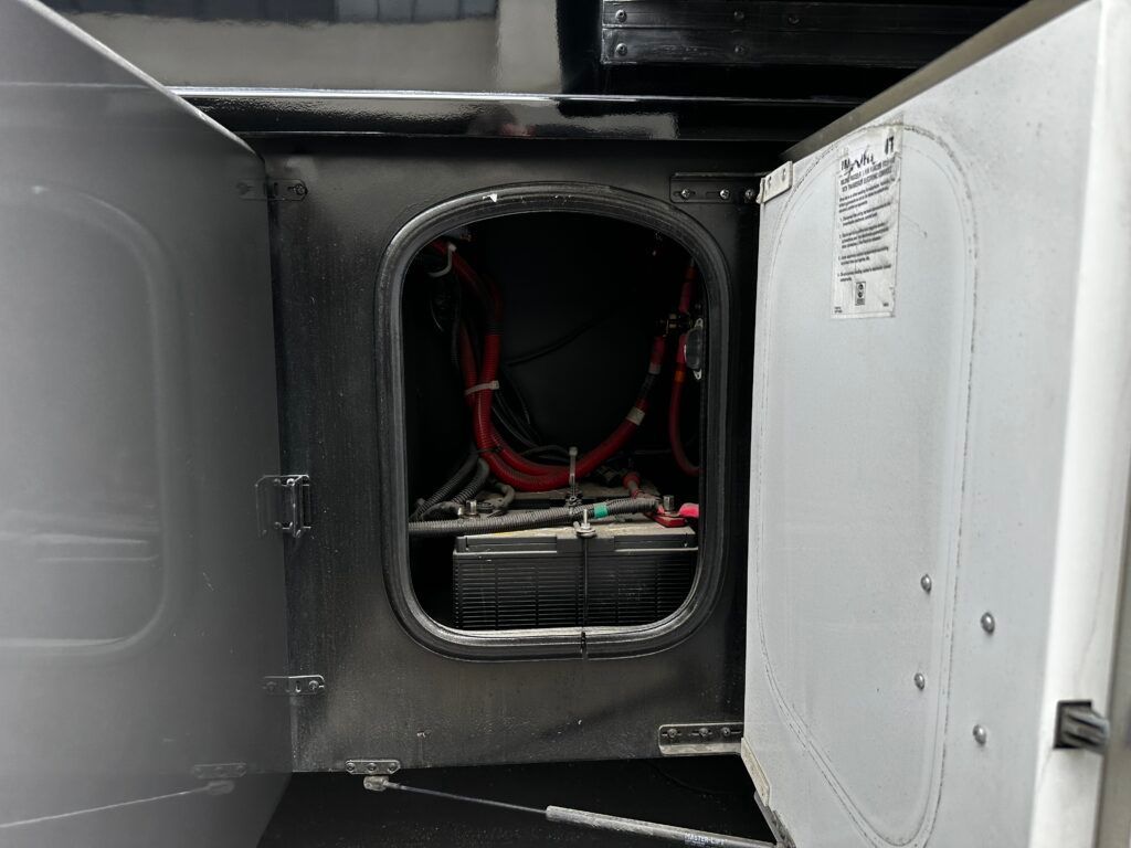 The inside of a vehicle with the door open and a battery inside.