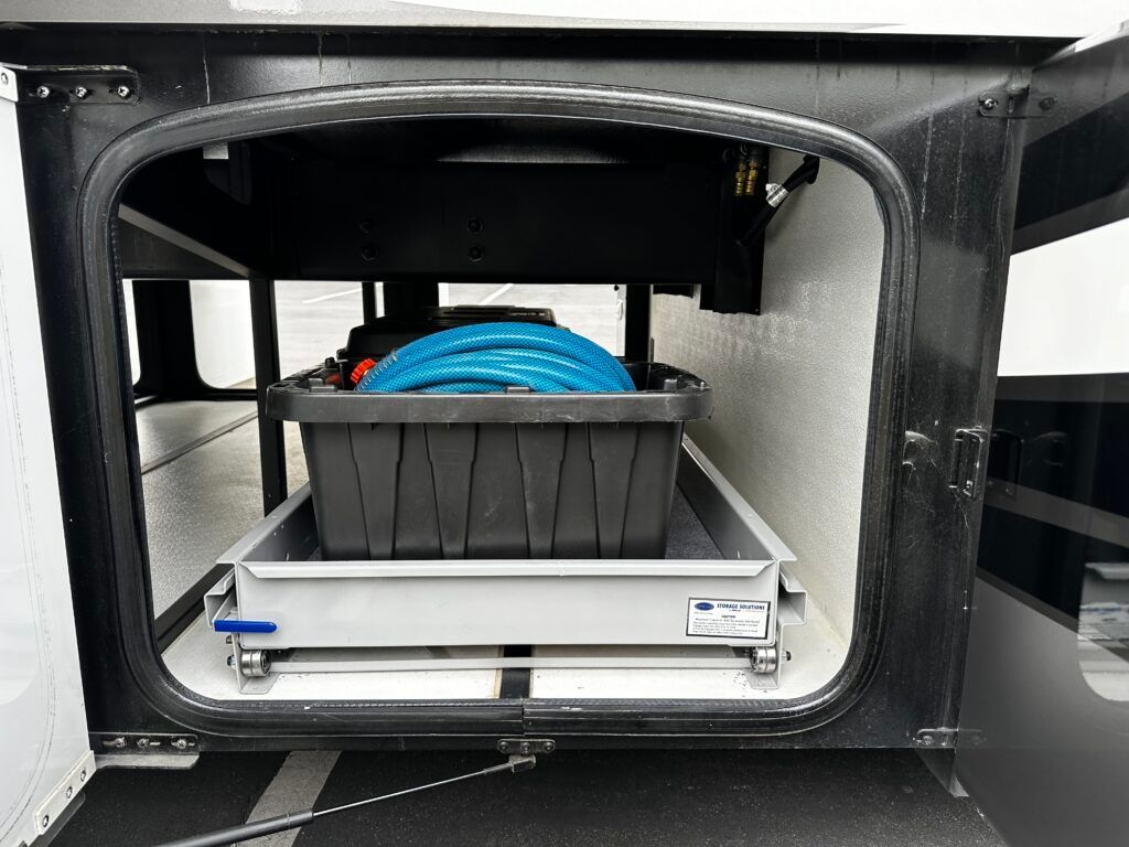 A black box with a blue hose in it is in the back of a trailer.