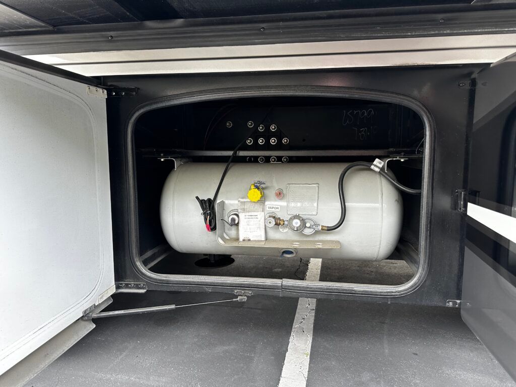 A propane tank is sitting in the back of a vehicle.