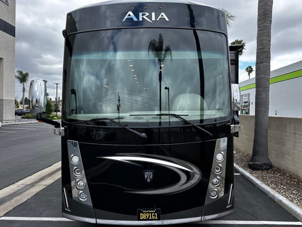 A black aria rv is parked in a parking lot.