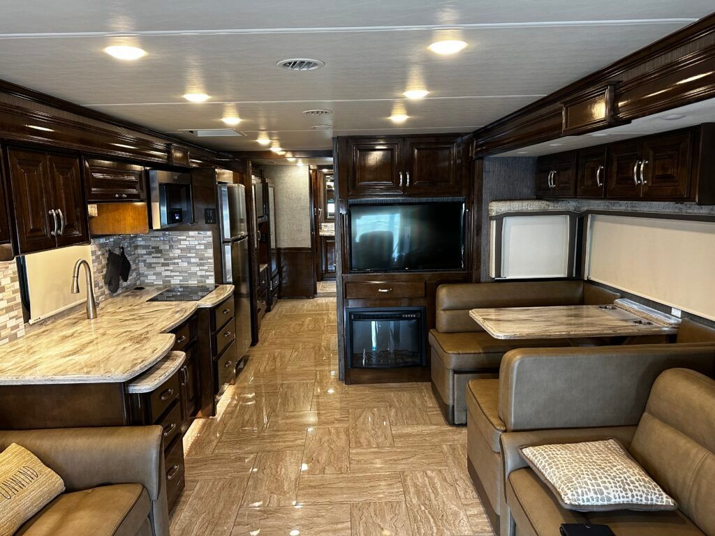 A living room with a couch , table and television in a rv.