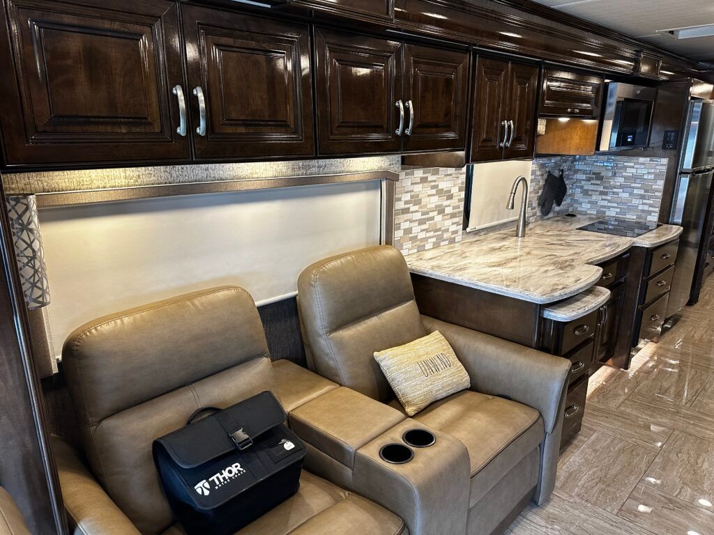 A living room in a rv with two chairs and a briefcase.