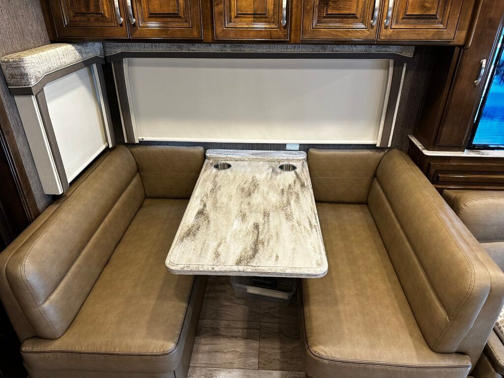 A dining room in a rv with a table and couch.