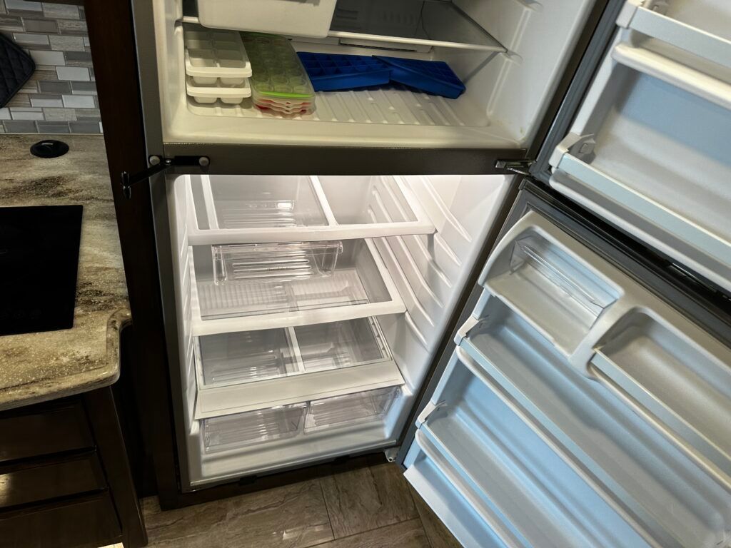 A refrigerator with the door open in a kitchen.