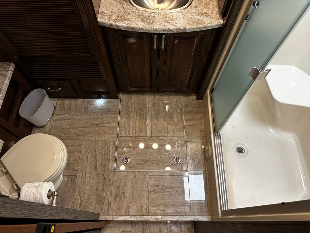 A bathroom with a toilet , sink , and shower.