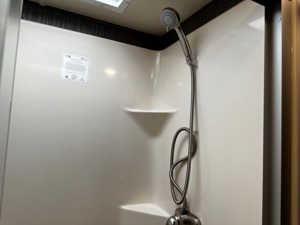 A shower with a shower head and a hose attached to it.