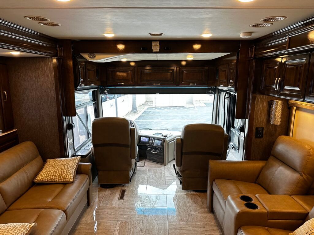 The inside of a rv with a couch and chairs