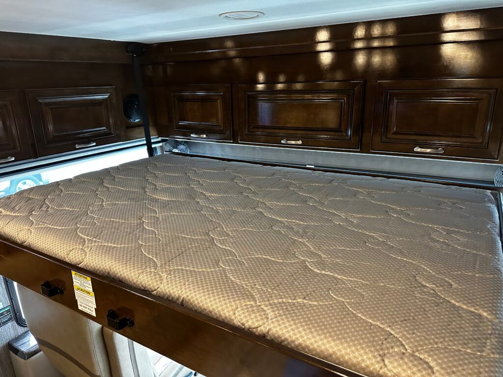 A mattress is sitting on top of a bunk bed in a rv.