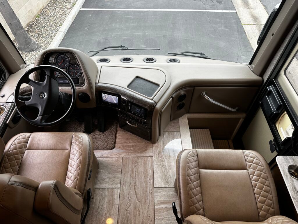 The interior of a bus with a steering wheel and seats.