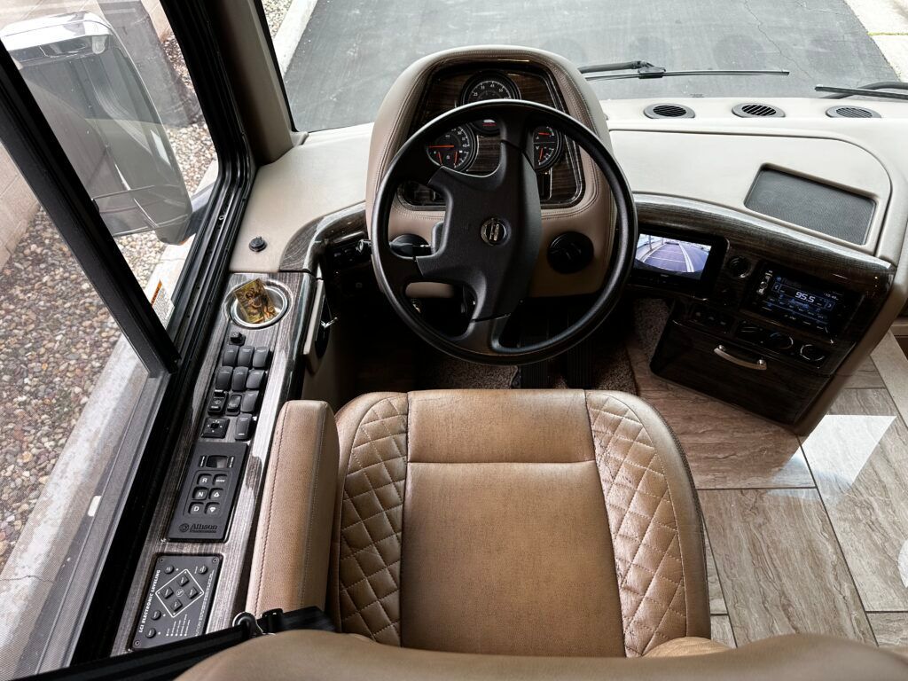 The interior of a bus with a steering wheel and seats