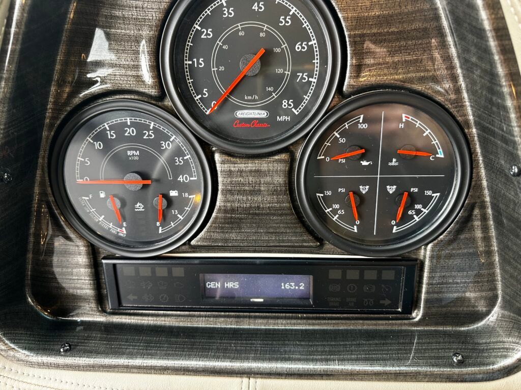A close up of a dashboard with three gauges and a clock
