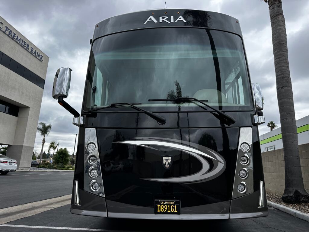 A black aria bus is parked in a parking lot.