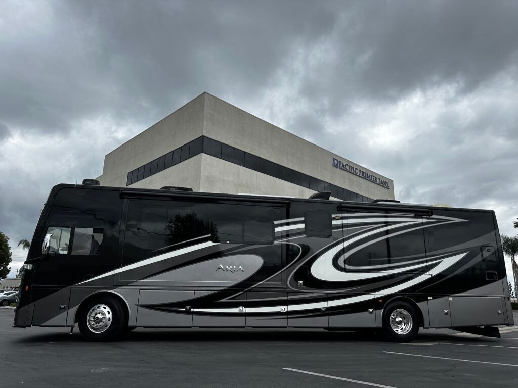 A large black and white bus is parked in front of a large building.