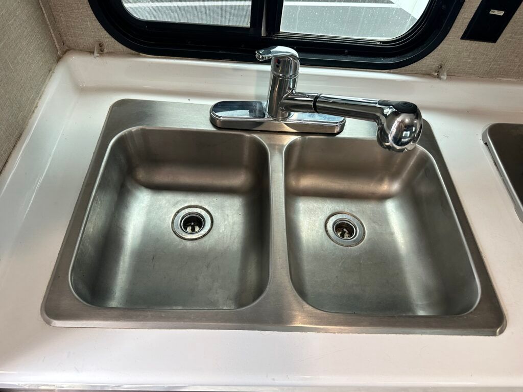 A stainless steel kitchen sink with two sinks and a faucet.