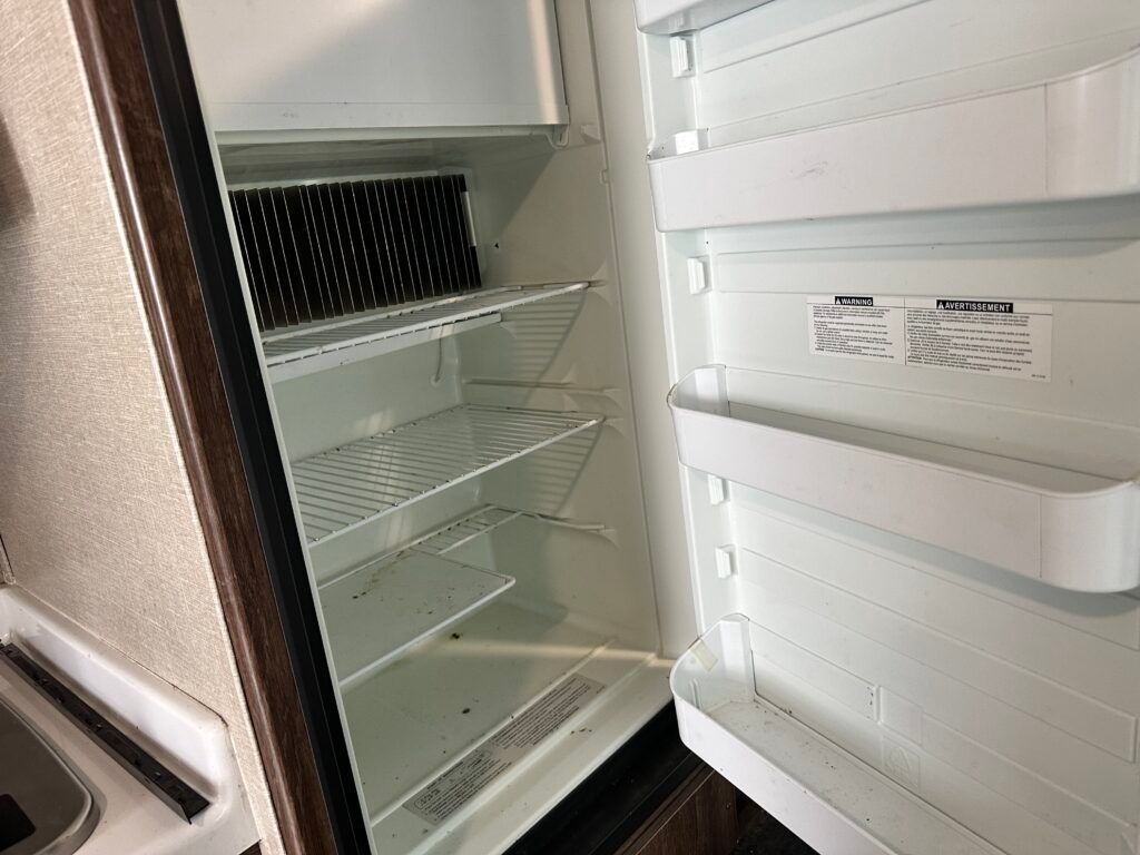 The inside of an empty refrigerator with the door open.