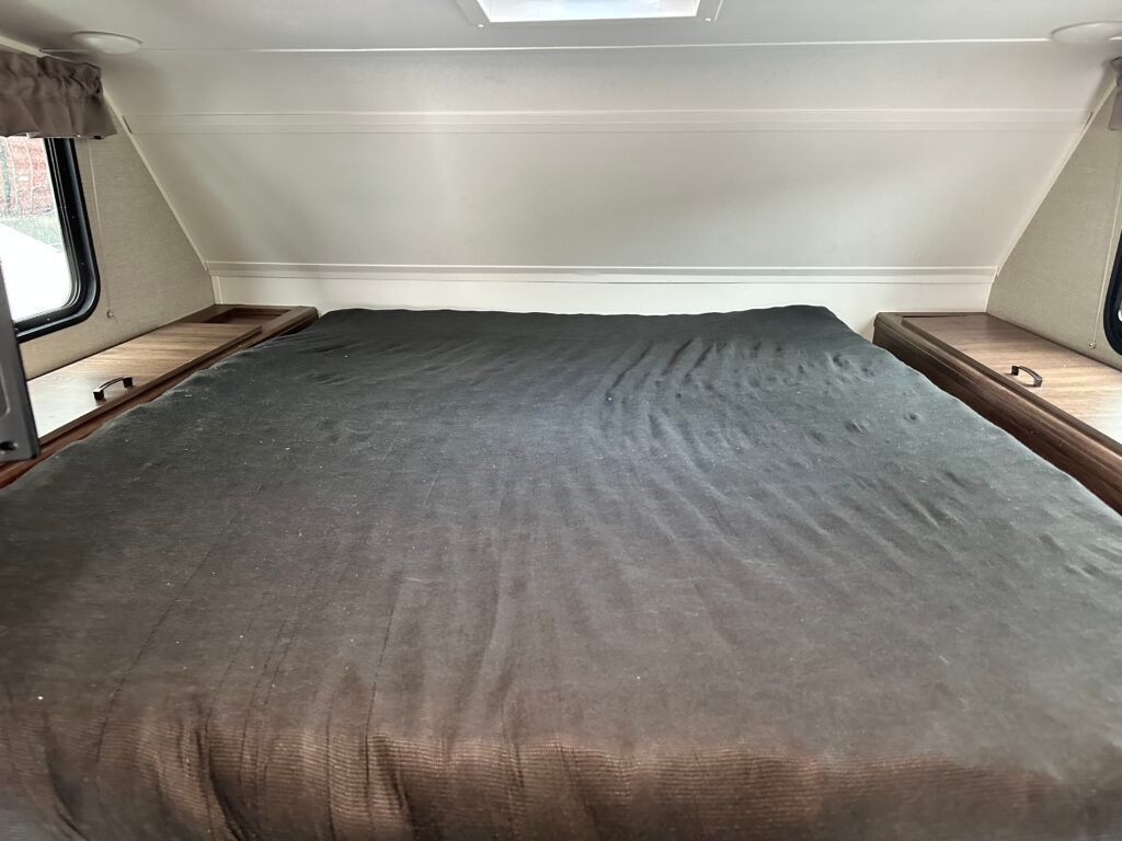 There is a bed in the back of a camper.