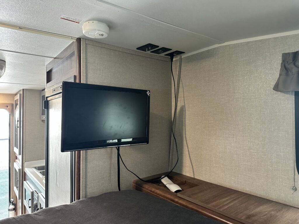 A flat screen tv is mounted on a wall in a rv.