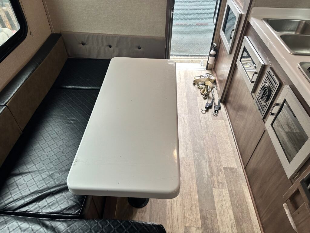 A kitchen with a table and a black couch
