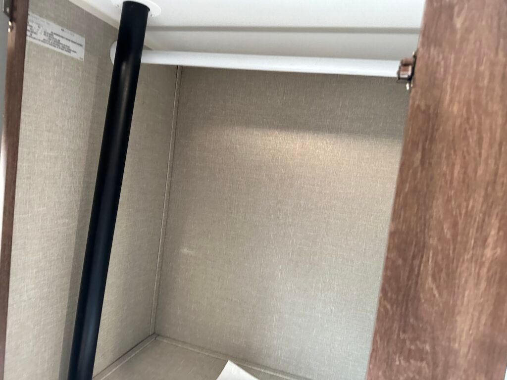 A closet with a shelf and a light on the ceiling.