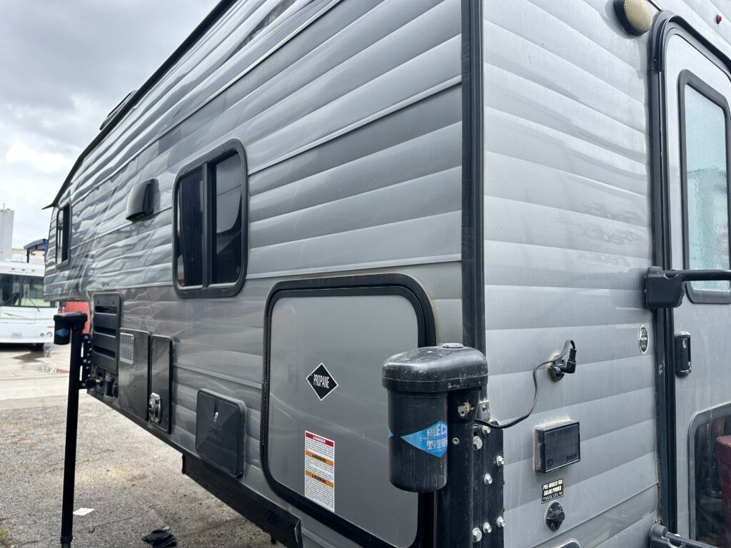 A silver trailer is parked in a parking lot.