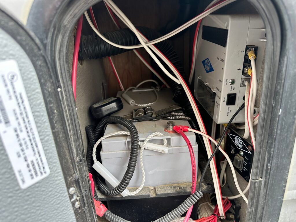 A bunch of wires are connected to a battery inside of a vehicle.