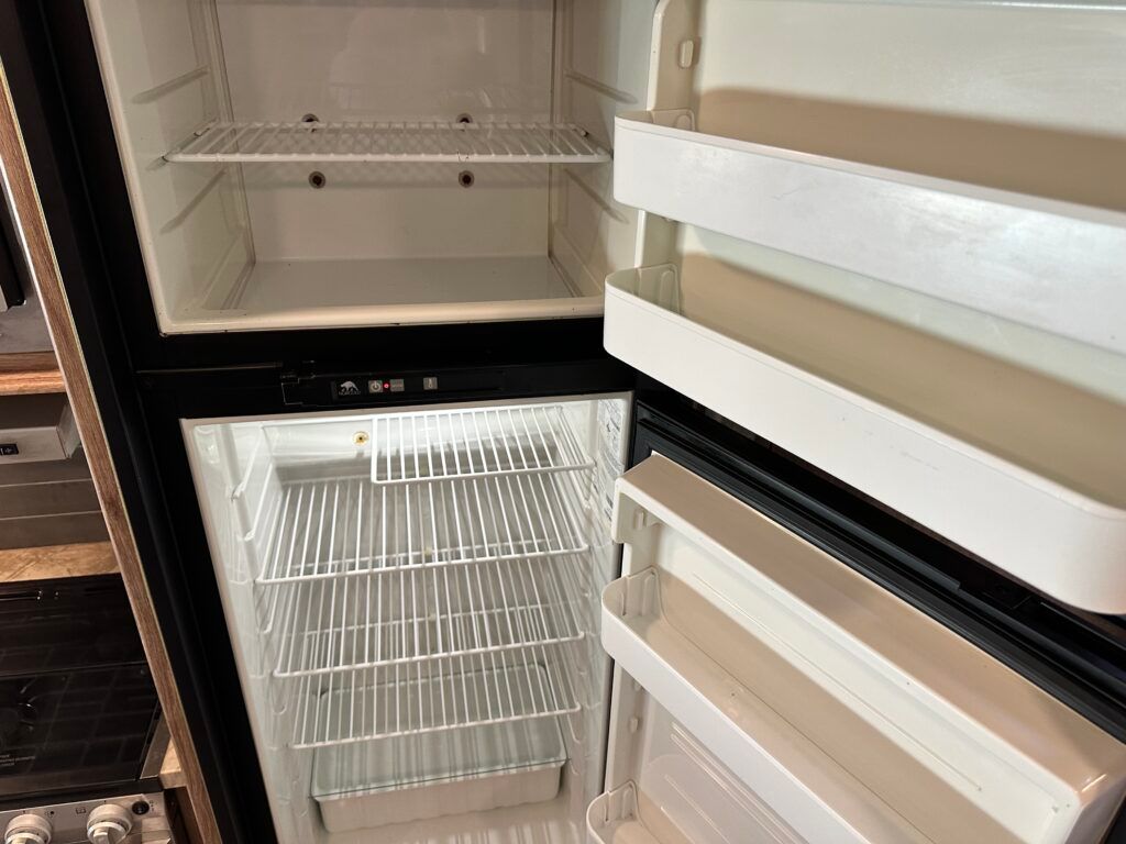 The inside of an empty refrigerator with the door open