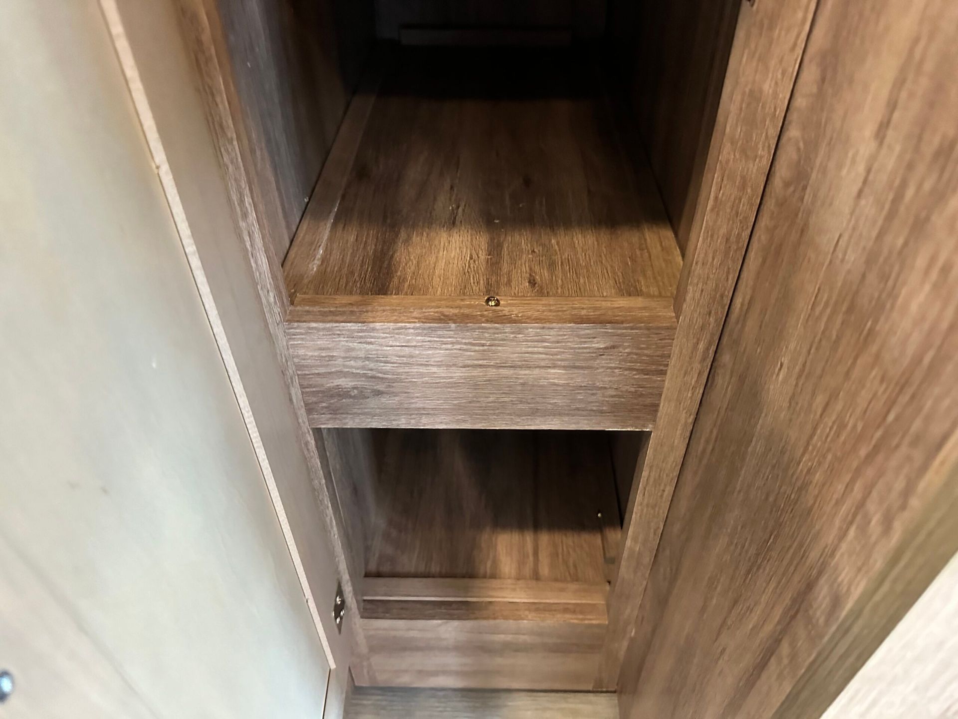 A wooden shelf in a closet with a drawer underneath it.