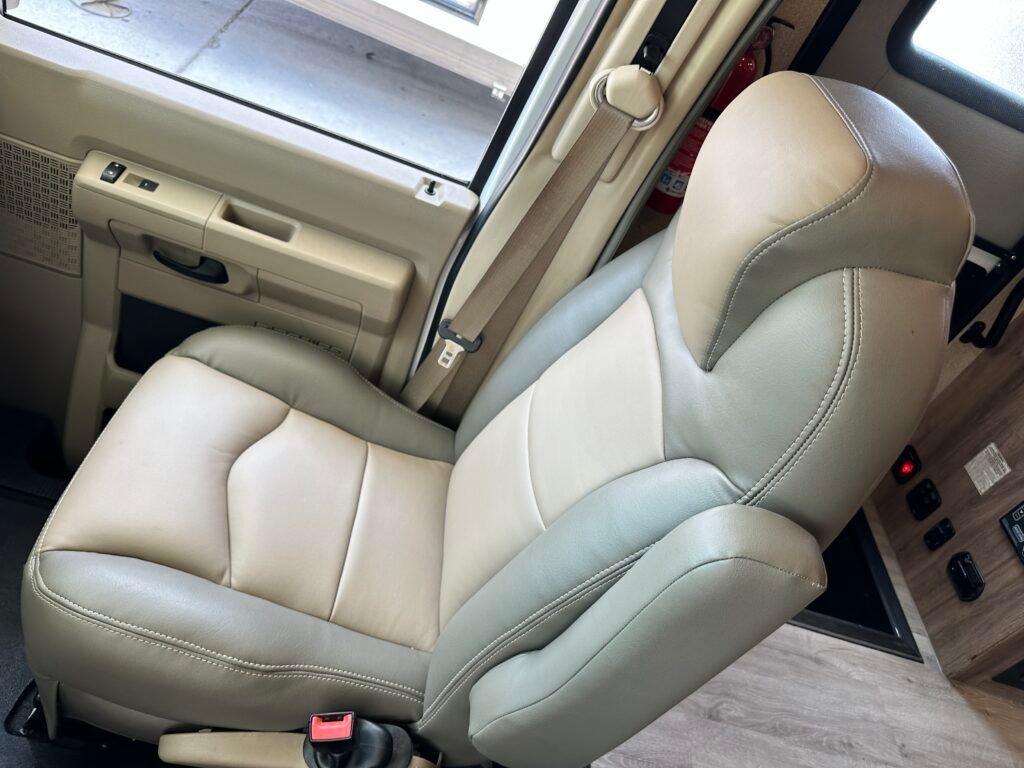A tan and gray leather seat in a vehicle.