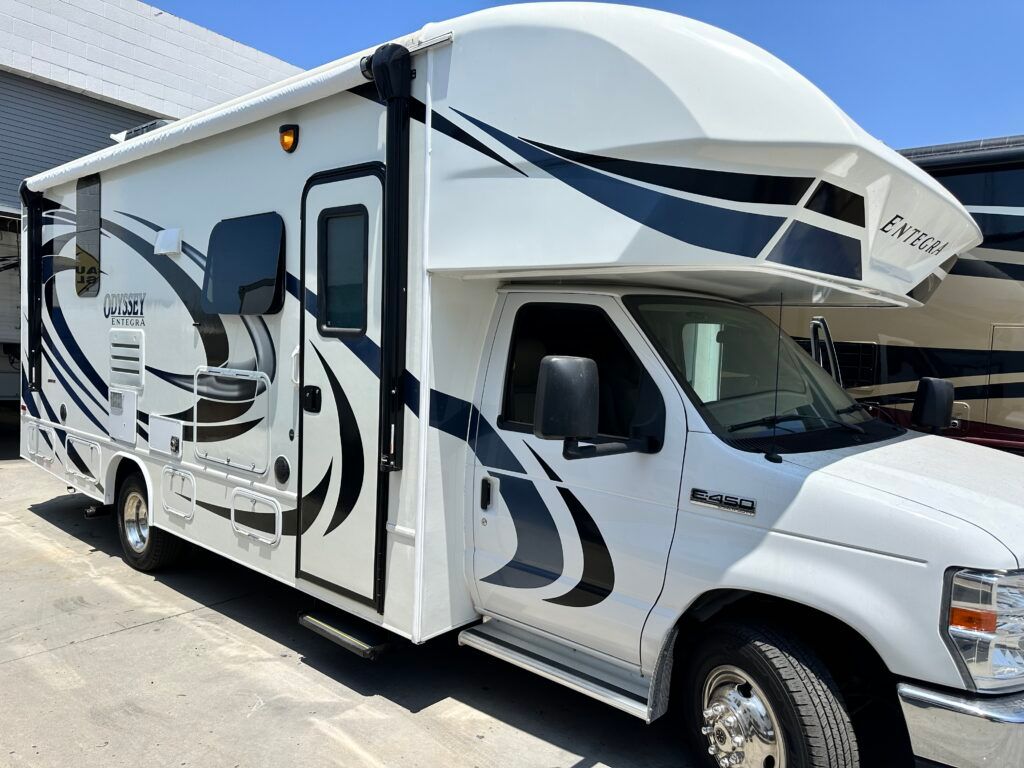 A white rv is parked in a parking lot.