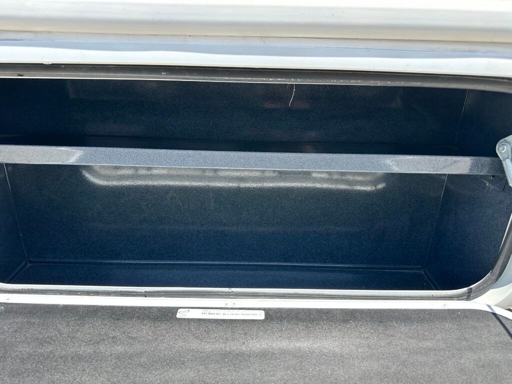 The trunk of a car is open and empty.
