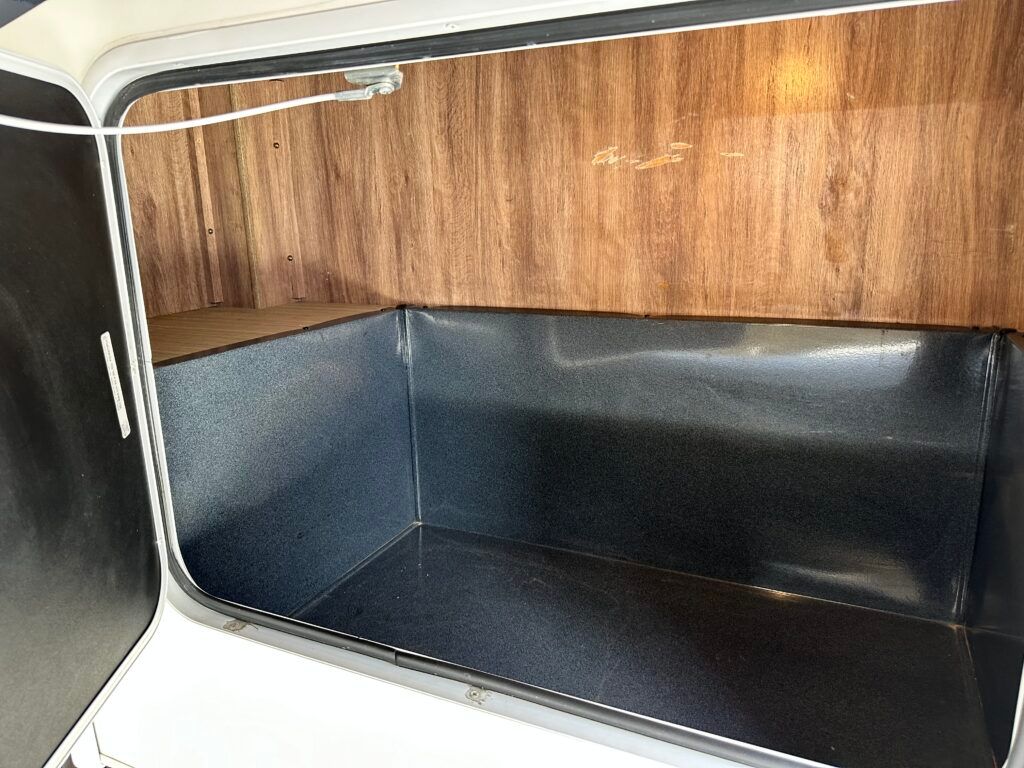 A black and white box with a wooden wall behind it.