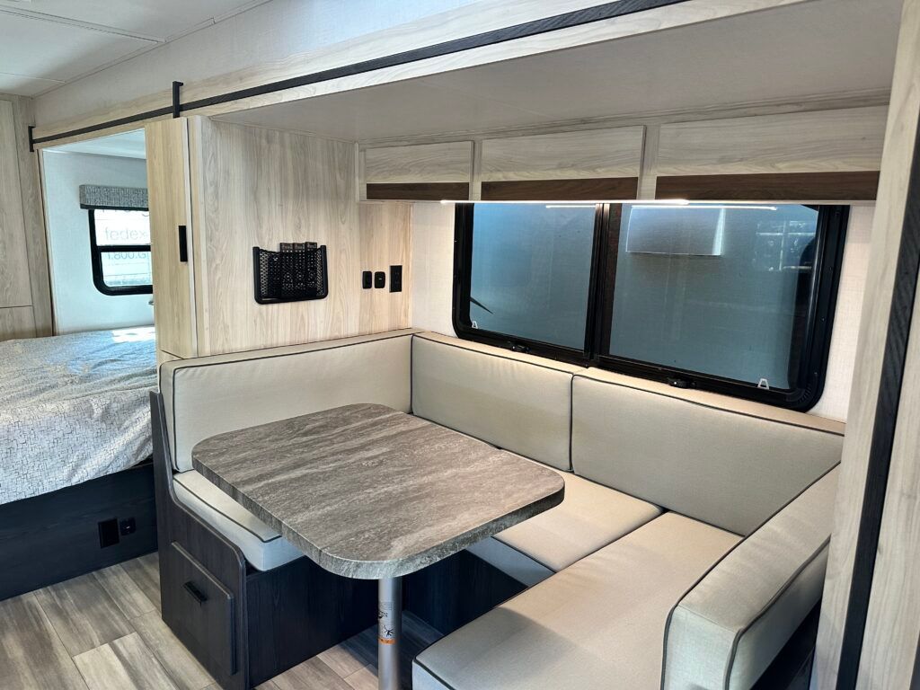 A rv with a table , benches , and a bed.