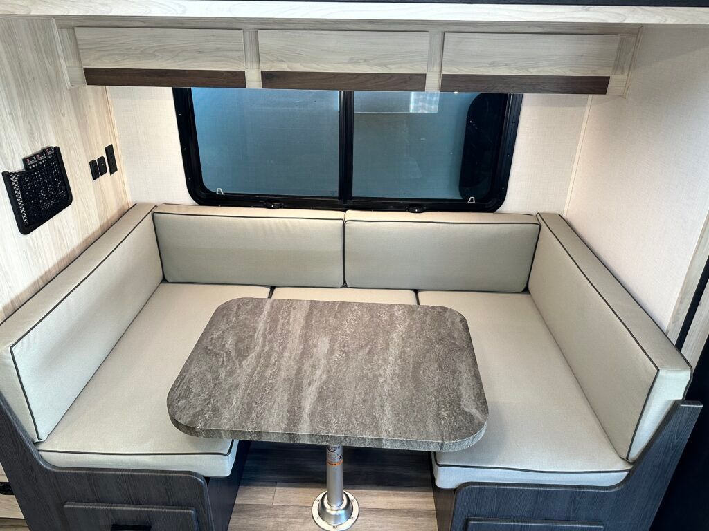 A rv with a table and couch in it.