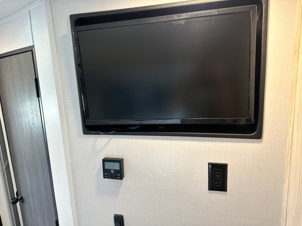 A flat screen tv is mounted on a wall in a room.