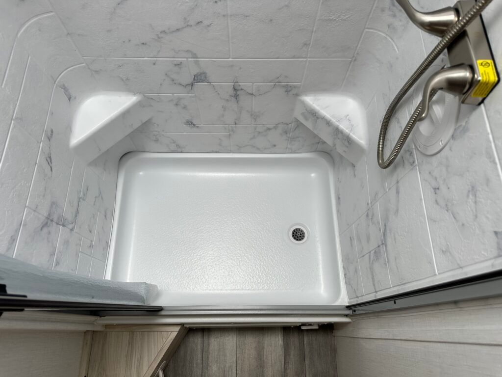 A bathroom with a walk in shower and a sliding glass door.