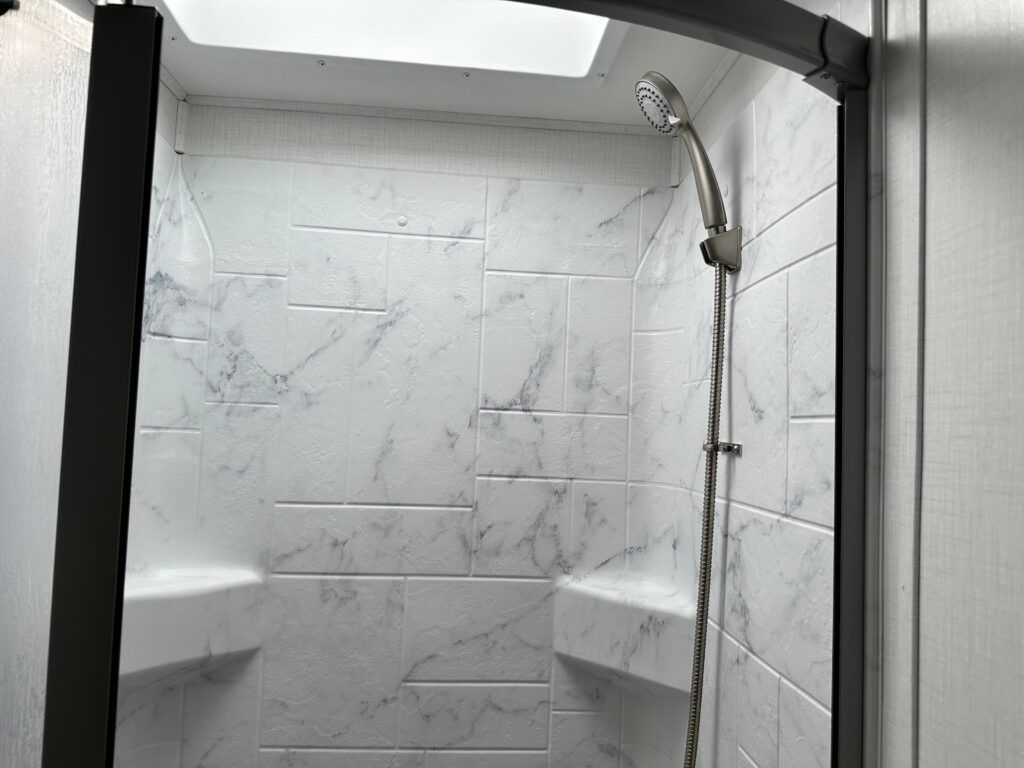 A shower with marble tiles and a shower head.