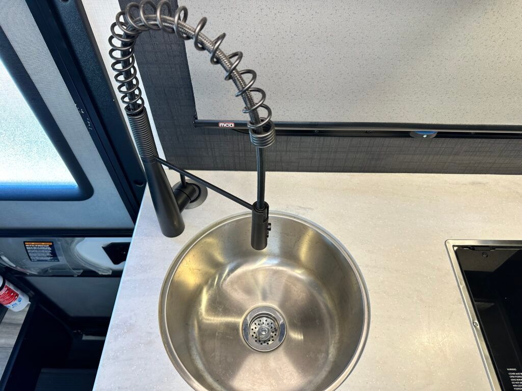 A stainless steel sink with a faucet attached to it.