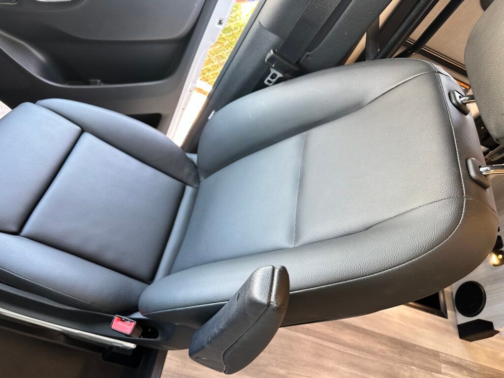 A black leather car seat is sitting in a car.