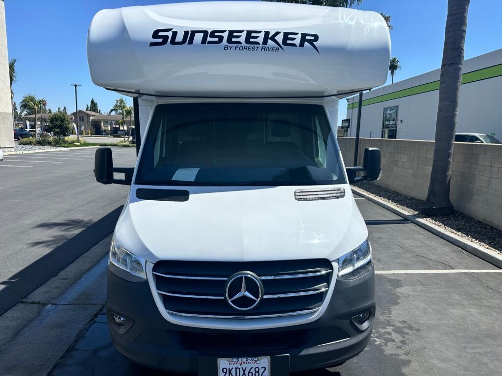 A white sunseeker rv is parked in a parking lot.