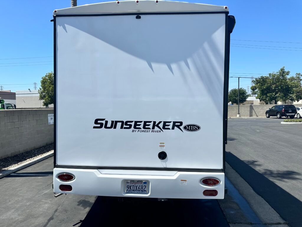 A white sunseeker rv is parked in a parking lot