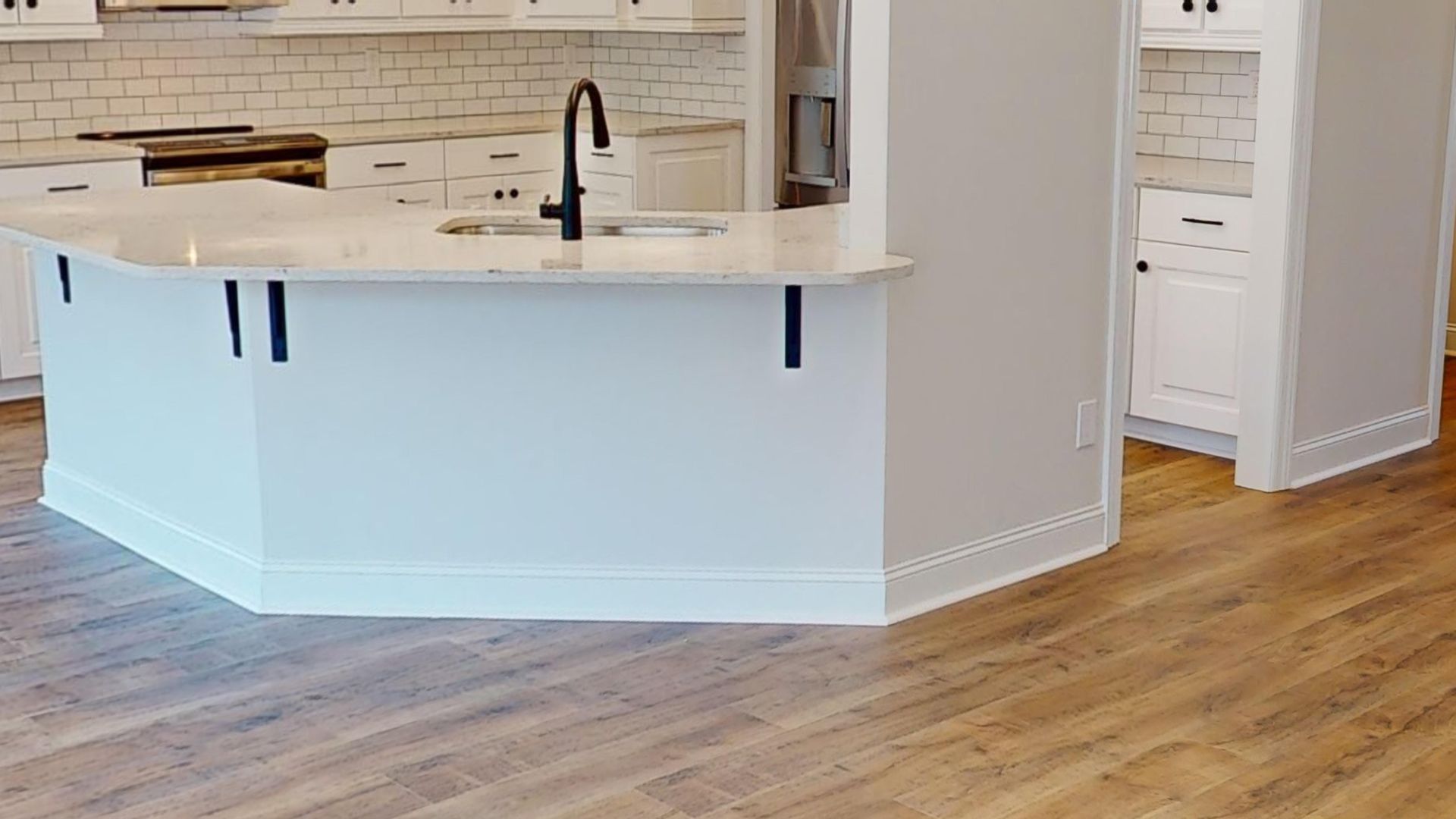 Kitchen island with a white countertop and black supports.