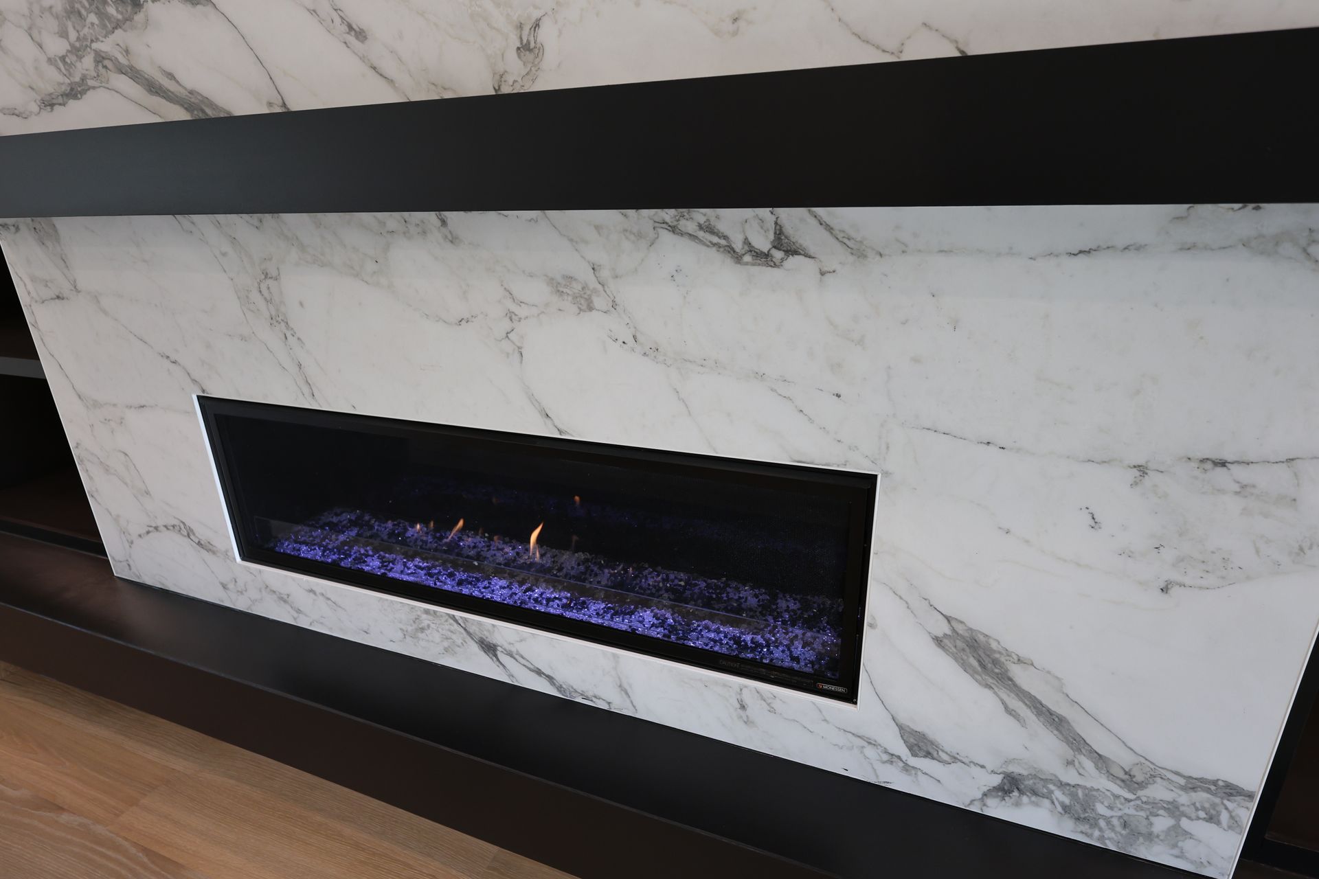 Fireplace with marble surround and black trim.
