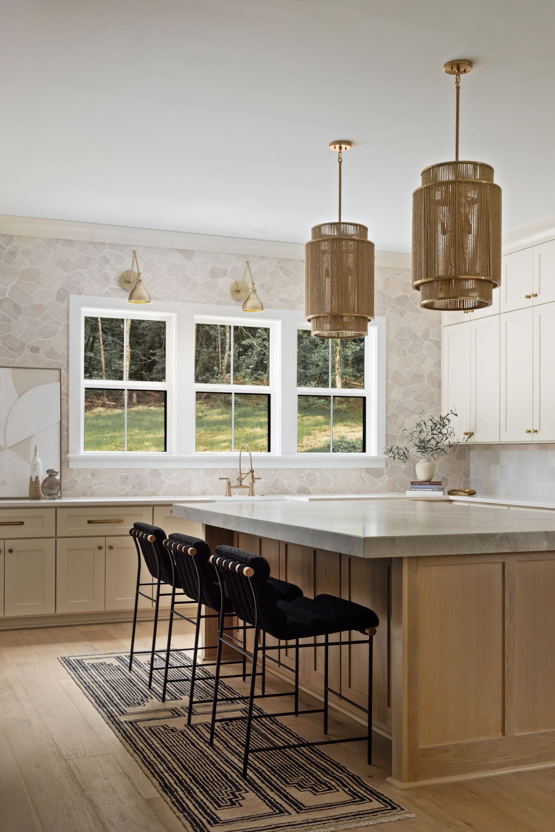 Kitchen with island, light wood cabinets, cream-colored countertops, large windows, and pendant lights.