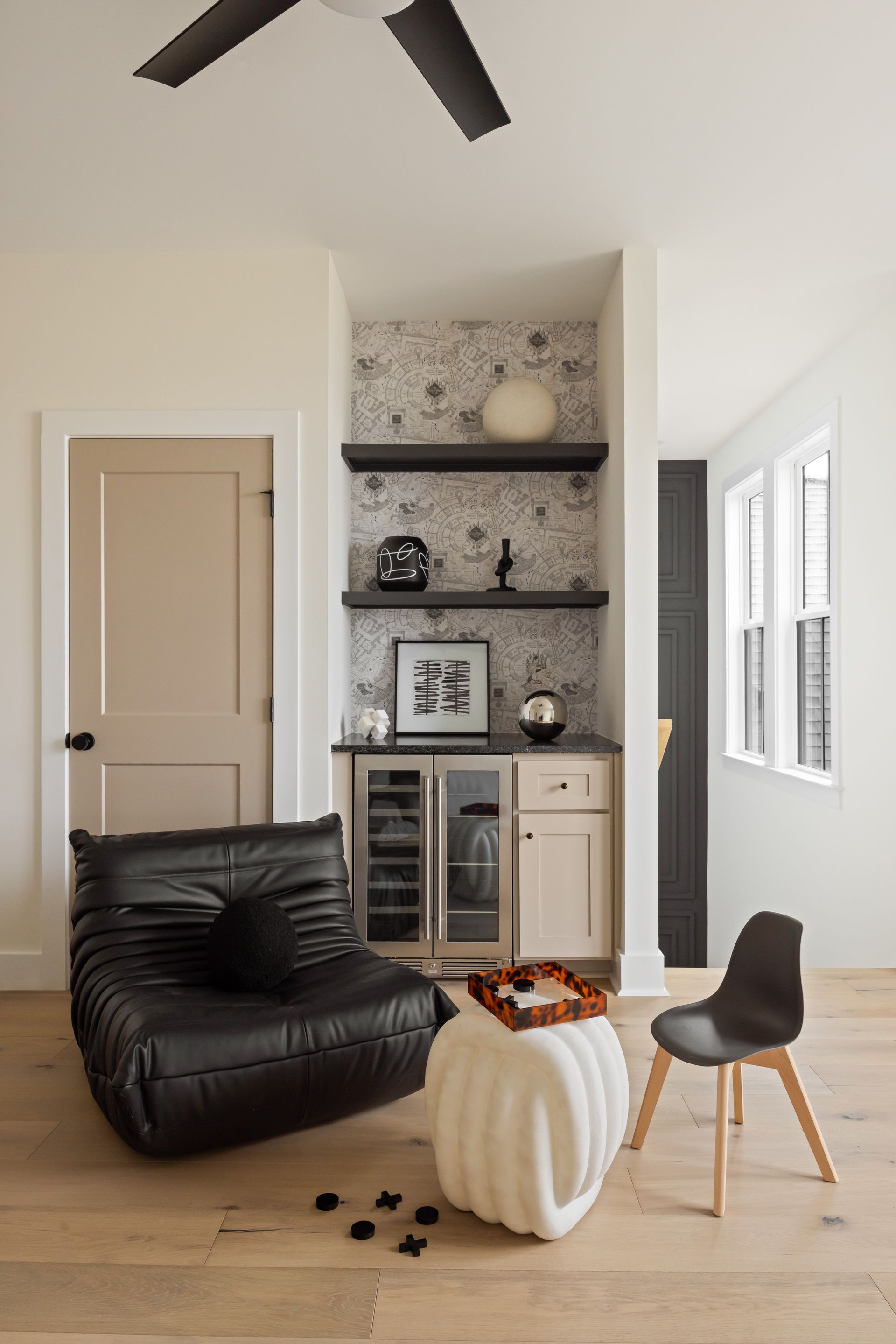 Modern home lounge with black leather chair, bar area, and decorative accents.