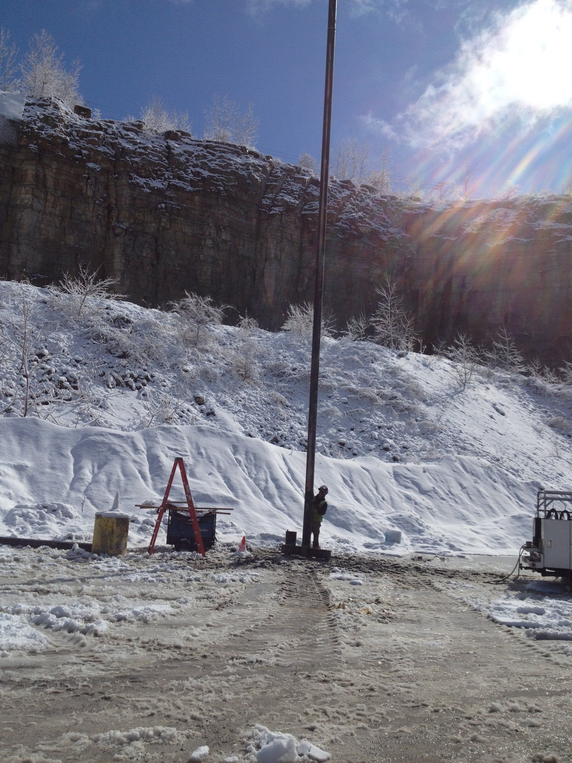 a man is standing next to a pole in the snow