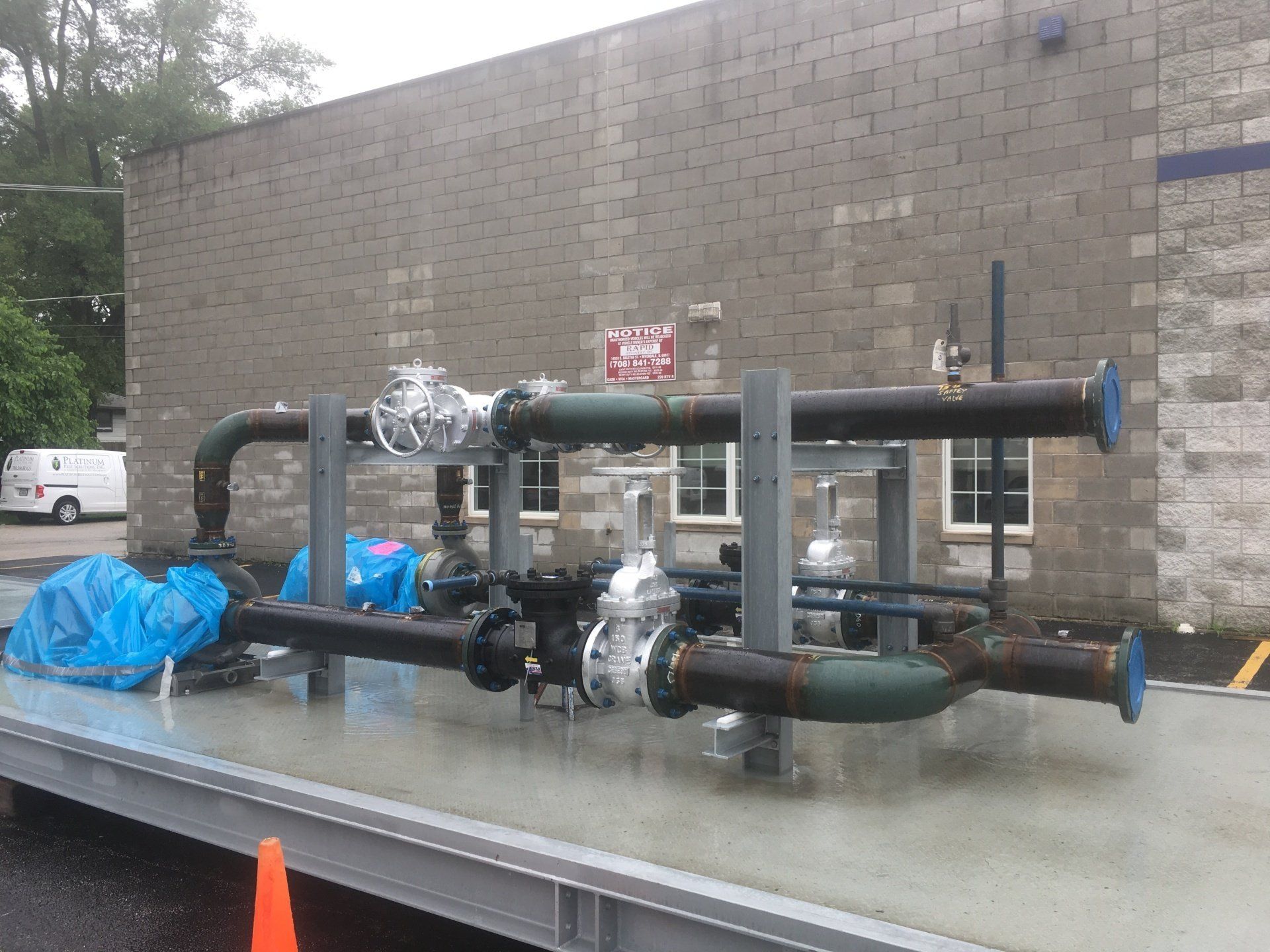 a bunch of pipes are sitting in front of a brick building.