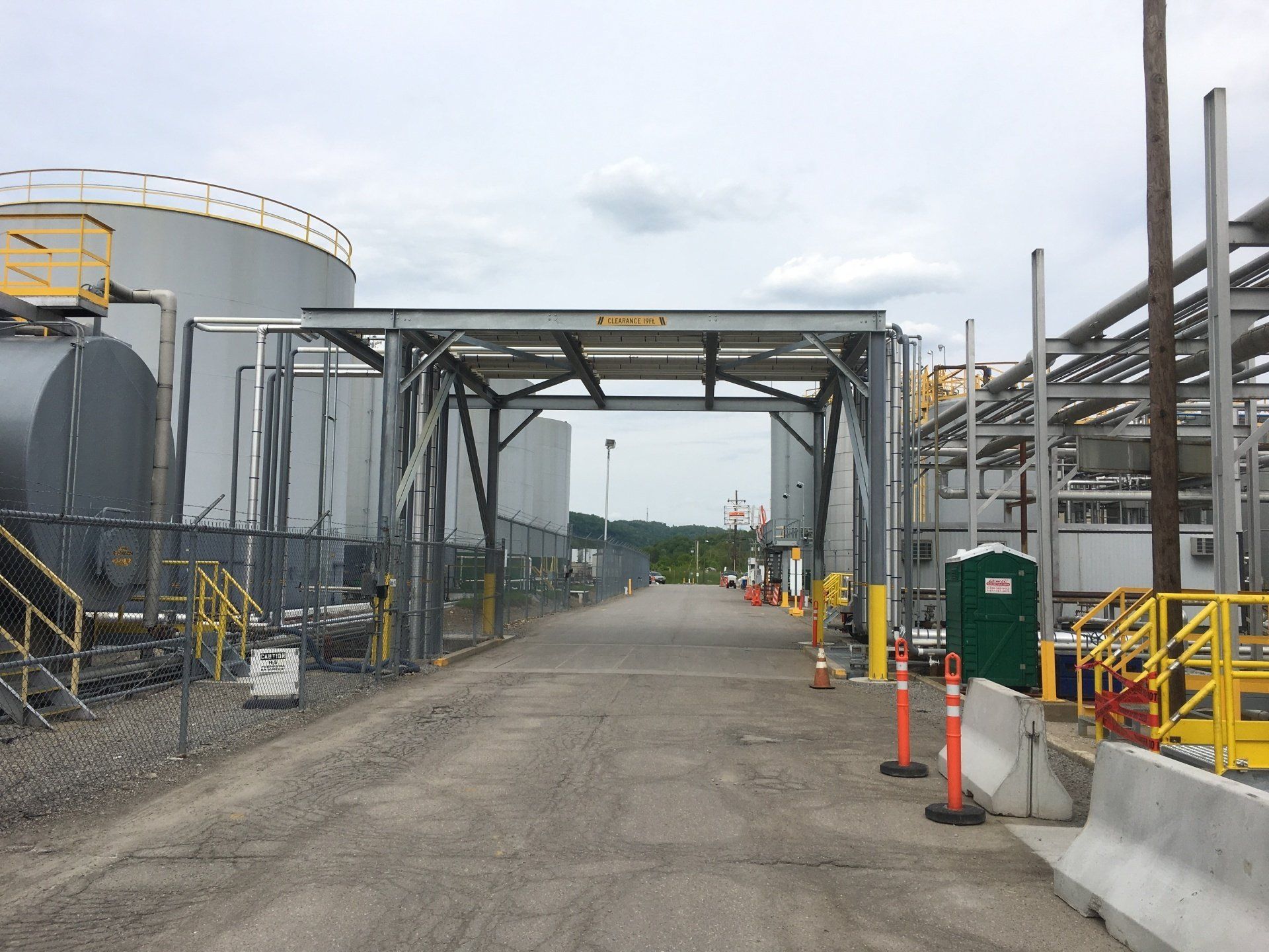 a fenced in area with a large tank in the background